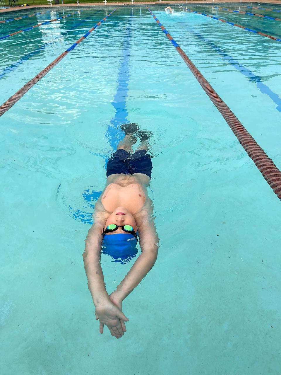 boy with swimming goggles and swimming cap diving at splashmates swim school